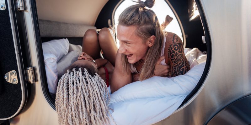 Laughing man in a vehicle talking to a woman