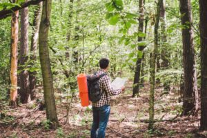 man searching map for directions in wilderness area